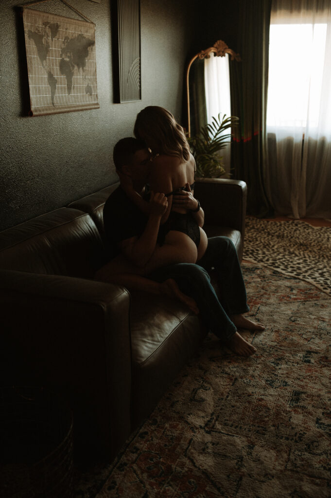 couple holding each other closely in soft lighting during intimate photo session