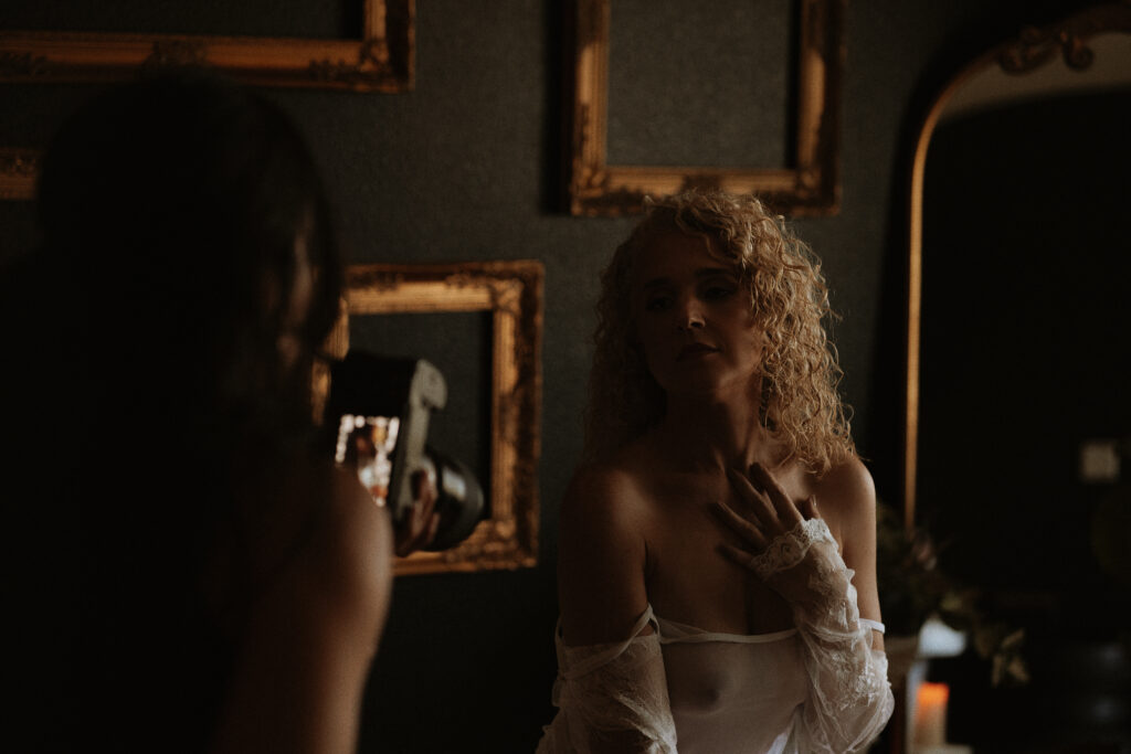 boudoir photographer guiding client through posing and movement during a confidence focused session
