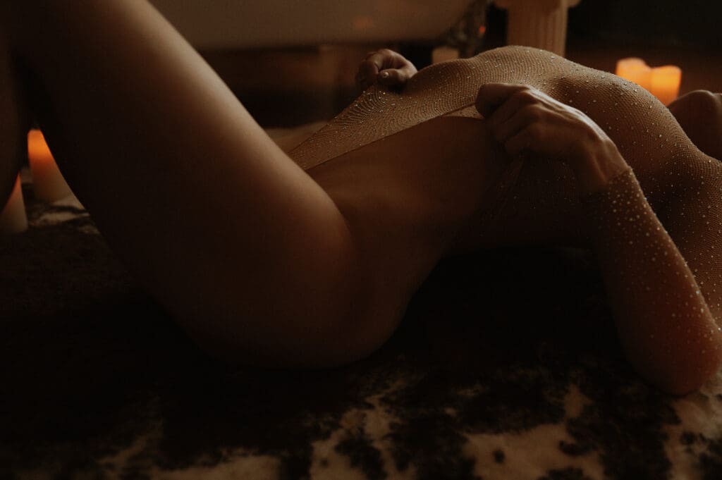 What Actually Changes After Your Second Boudoir Session: Woman pulling at her styled bodysuit during her second boudoir experience with Onyx and Sage Studios