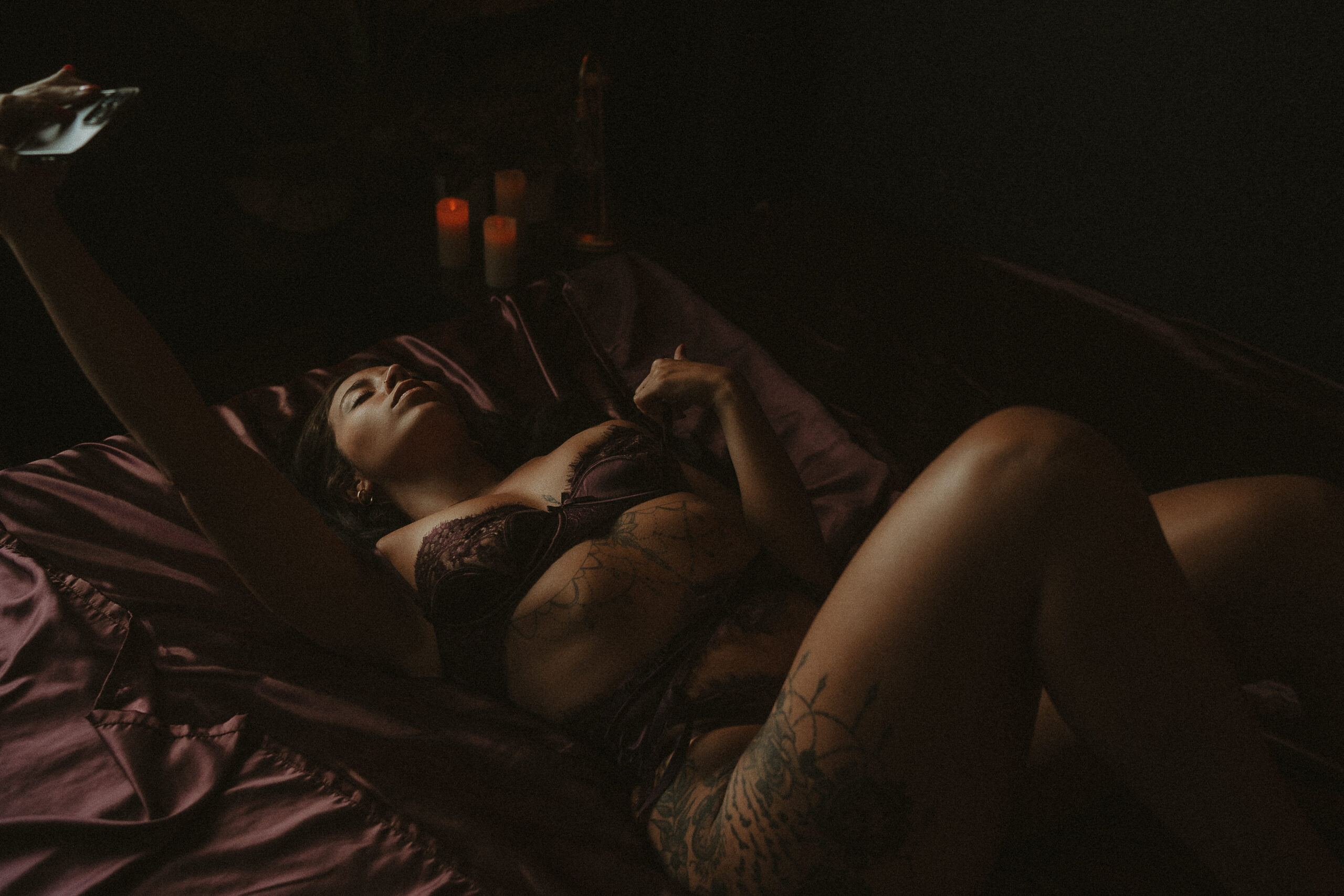 Woman in lace lingerie reclining on a satin bed for The MILFication of Motherhood editorial by Onyx & Sage Studios.